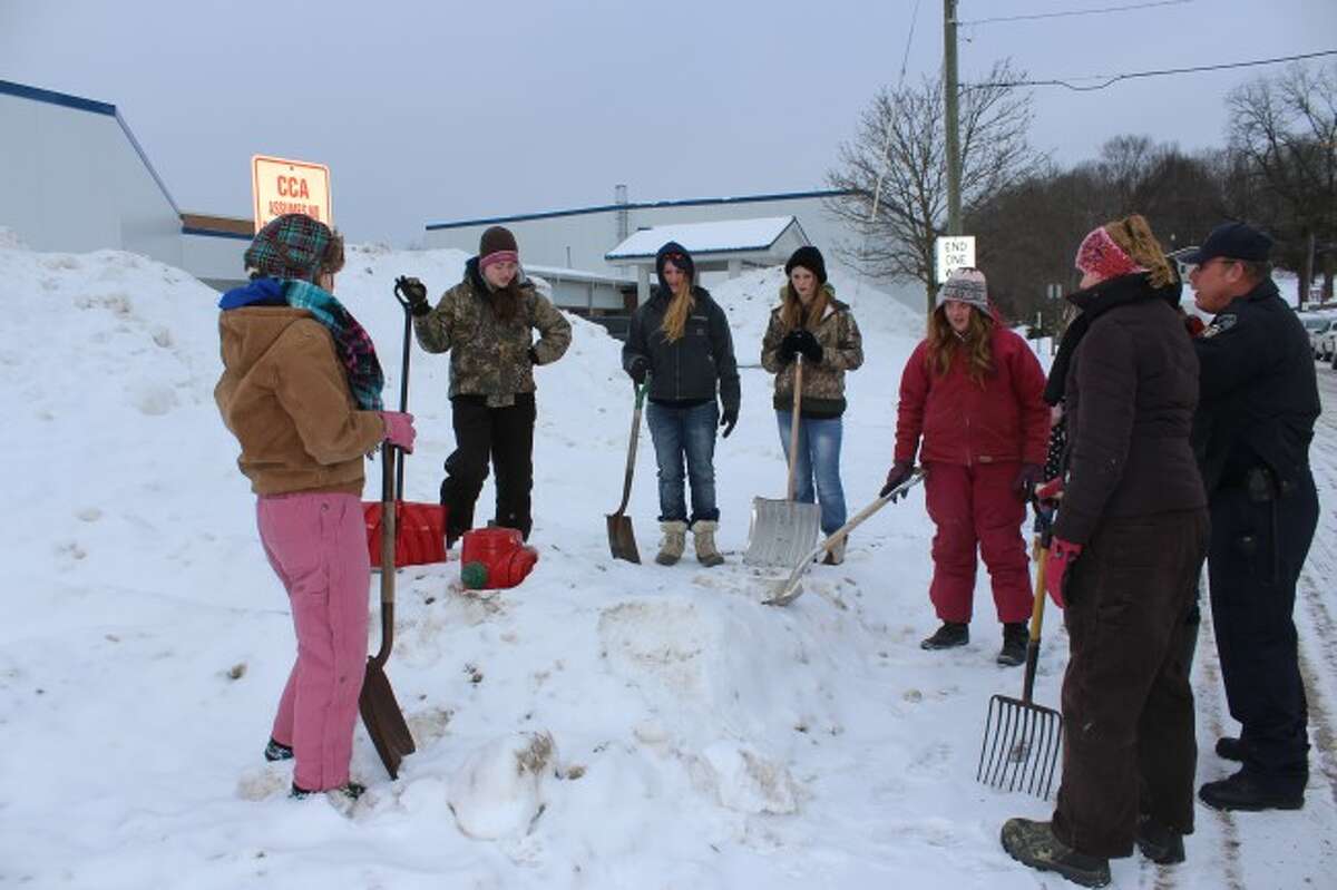 DIGGING OUT: Area 4-H Club helps Big Rapids Department of Public Safety firefighters clear snow away from fire hydrants on Thursday.