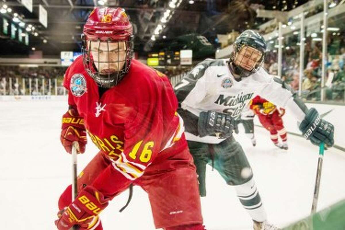 IN THE CORNER: Ferris State forward Garrett Thompson (16) digs a puck out of the corner boards earlier this season against Michigan State at Munn Ice Arena. Thompson and the Bulldogs will host the Spartans at 5:05 p.m. on Saturday. (Courtesy photo/Ferris State University)