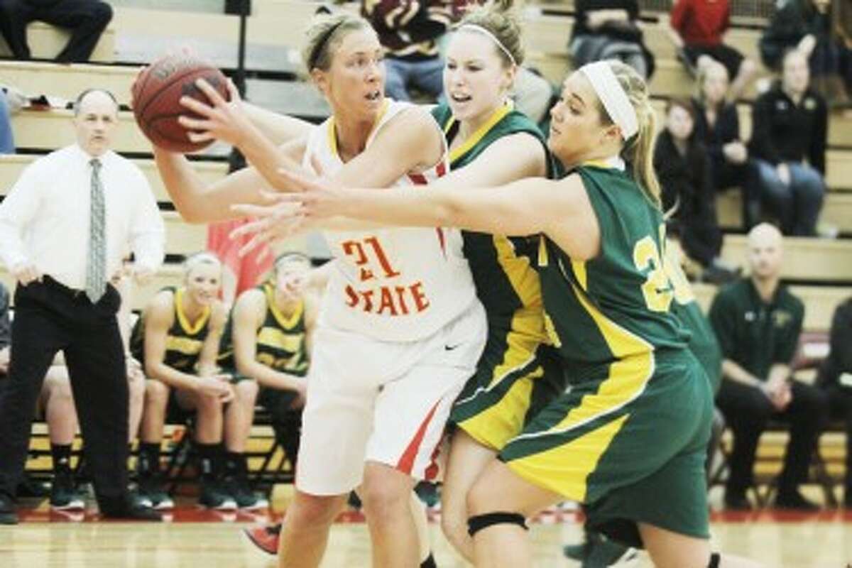 PRESSURE: Ferris State’s Kara Hess (21) looks to find an open teammate while being hounded by a pair of Northern Michigan defenders. The Bulldogs won the game 47-46. (Pioneer photo/Martin Slagter)