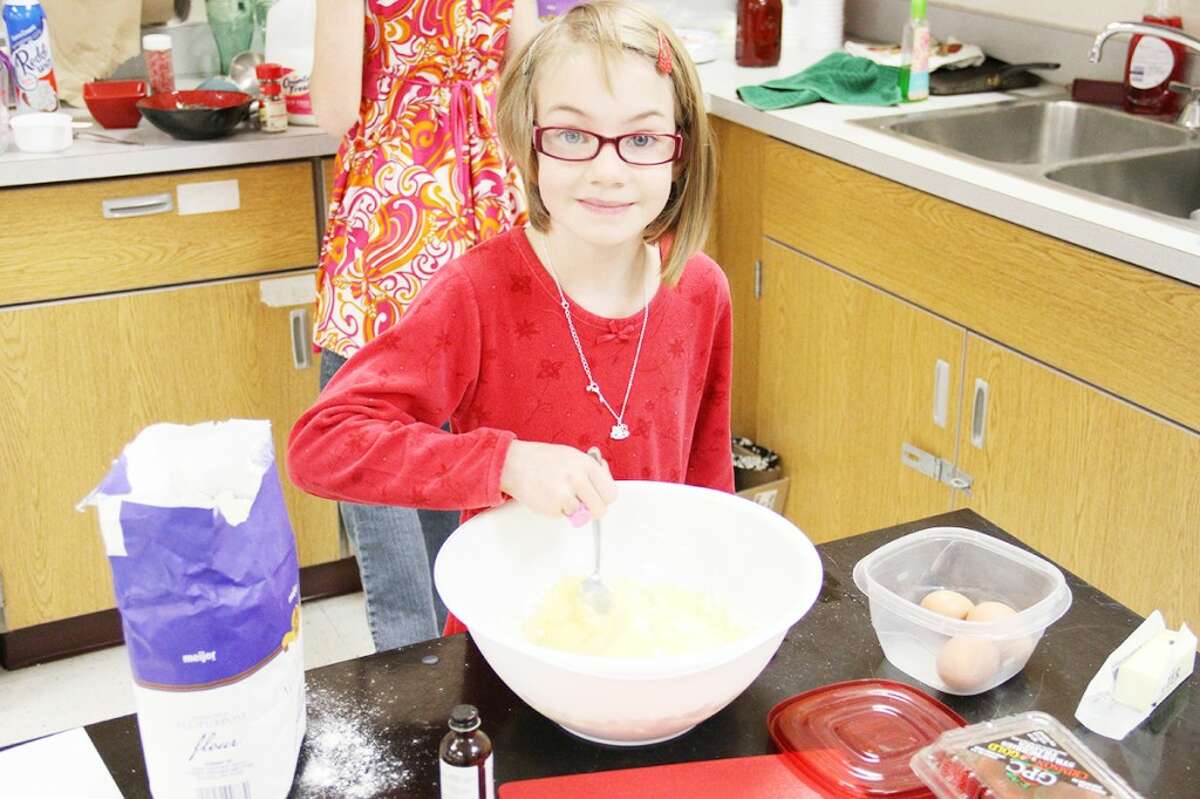 STIRRING: Megan Ebels, 7, stirs ingredients together to make German puff pancakes. Megan won the junior prize at the competition. (Pioneer photos/Sarah Neubecker)