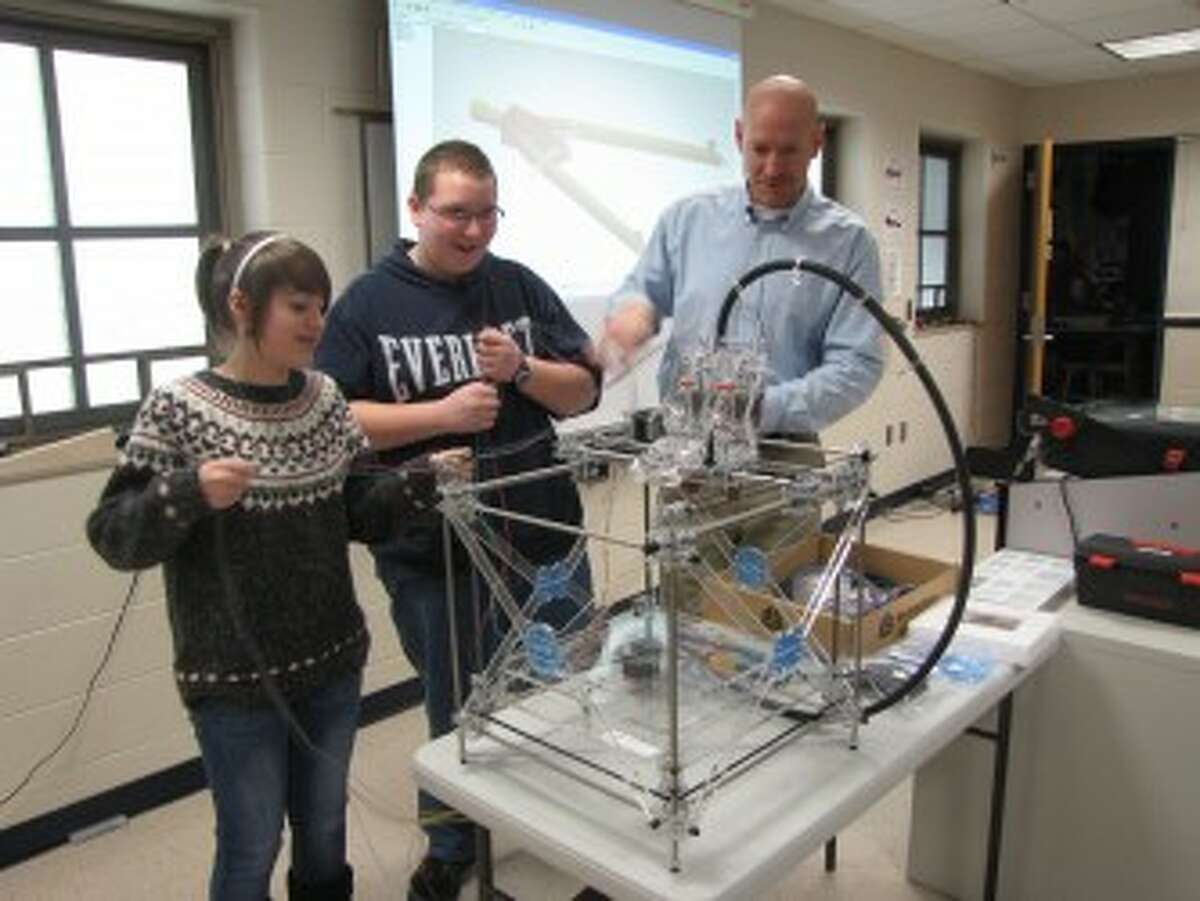 ASSEMBLY REQUIRED: CHIS technology teacher Rod Young and his students work on assembling a RapMan 3.2 kit the class received in December. The machine is a 3-D printer that turns images into objects. (Courtesy photo)