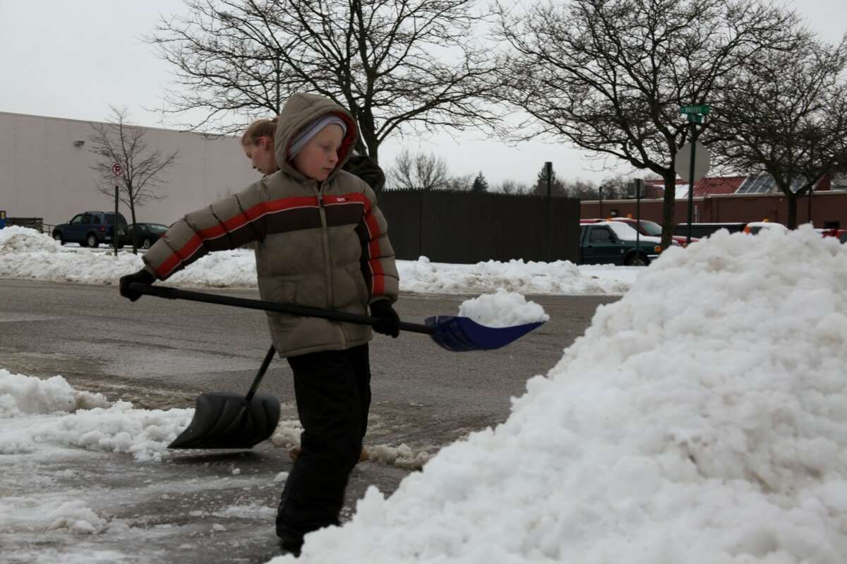 DAY OFF: Fourth grader Jacob Perrin helps his mother shovel their driveway. He also found time to watch movies and play games during his day off school on Monday.
