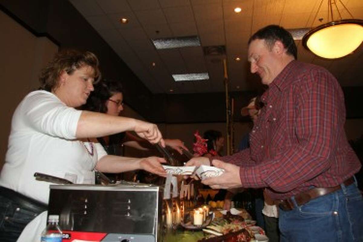 FINGER LICKIN’ GOOD: Jules Manley (left), of Gregory’s Grille, serves a basket of chicken to Brent Bazaire, of Barryton, during the 2012 Taste of Mecosta. This year’s event will be held on Feb. 12 at the Holiday Inn Hotel and Conference Center. (Pioneer file photos)