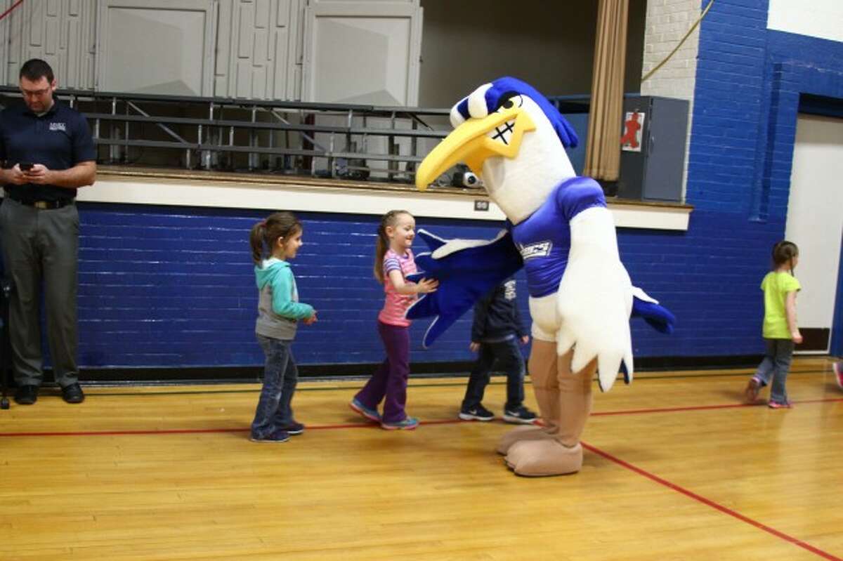 HAPPY HARRY: Students give high fives to Harry the Heron on Tuesday at Barryton Elementary School. As part of March is Reading Month, Mid Michigan Community College Associate Director of Admissions Brent Mishler read the children a book which featured Harry.