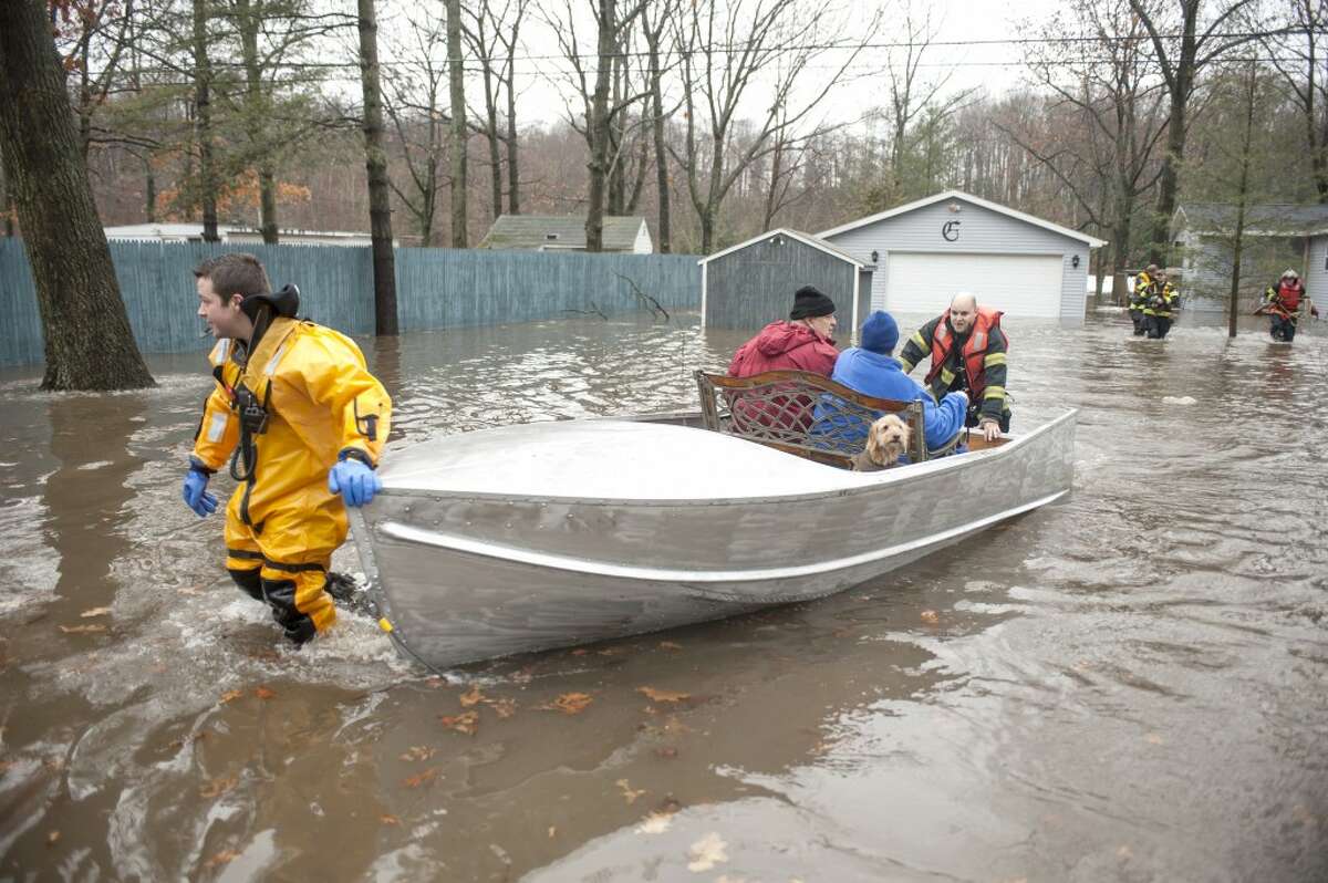 RESCUE: Emergency workers rescue a couple and their dog from their flooded home on 183rd Avenue in Mecosta Township. Residents of the low-lying road were forced to evacuate on Wednesday when flood waters surged. (Special to the Pioneer/Matt Yeoman)