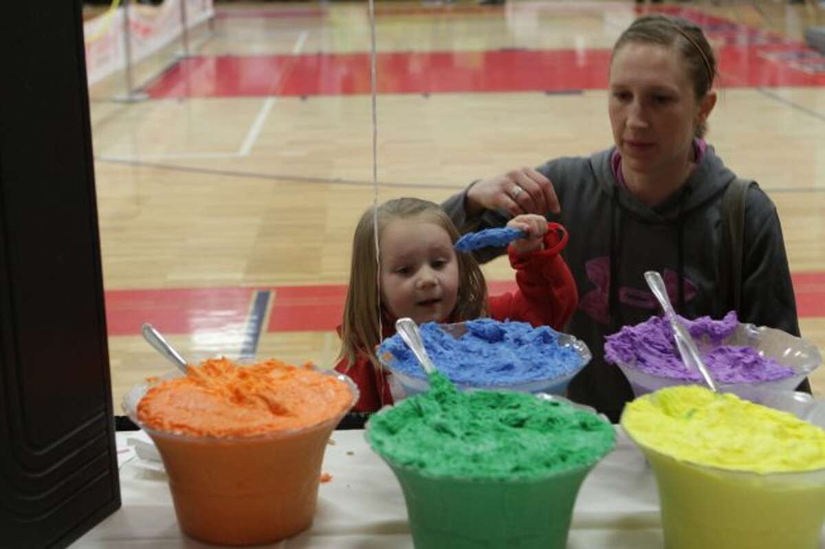 At a Ferris State University booth, young Nicole Frazier, and her mother Amanda, decide to frost a sugar cookie in blue.