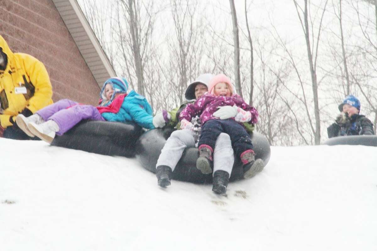 TUBING: Elizabeth McDonald tubes down a hill at Cran-Hill Ranch with her daughter, Desiree Mead, at left, and her neice, Sophia Oliver, at right. Event-goers could tube down three hills at Winterfest on Sunday.