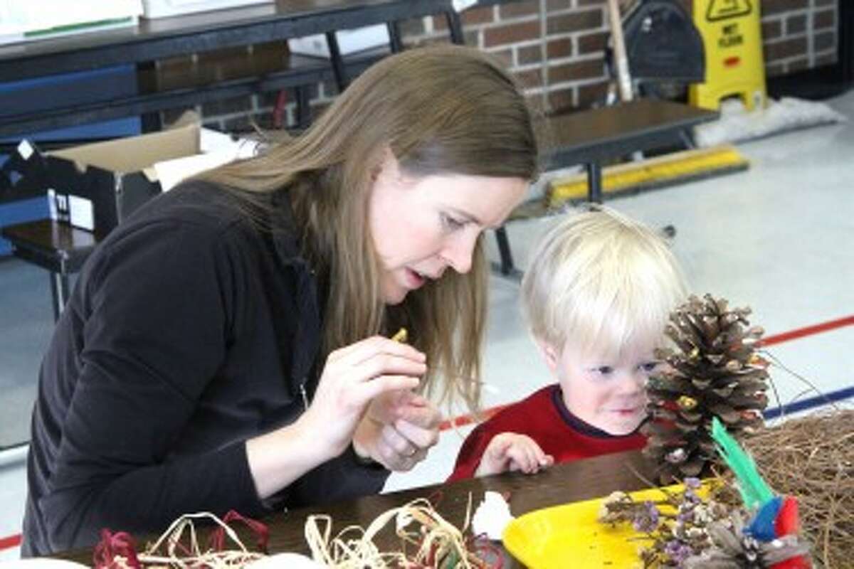 CREATING TOGETHER: Jenny Long and her son, Preston Long decorate a pinecone together at the “Wee Wonders” art workshop on Saturday. (Pioneer photos/Sarah Neubecker)