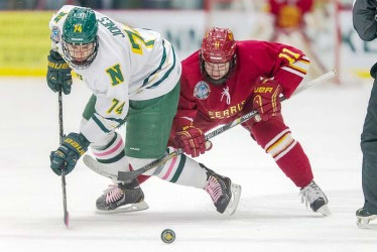 ON THE MOVE: Northern Michigan’s Mitch Jones (74) tries to escape the back check of Ferris’ Kenny Babinski (11) during Saturday’s CCHA contest. (Courtesy Photo/Ferris State Ben Amato)