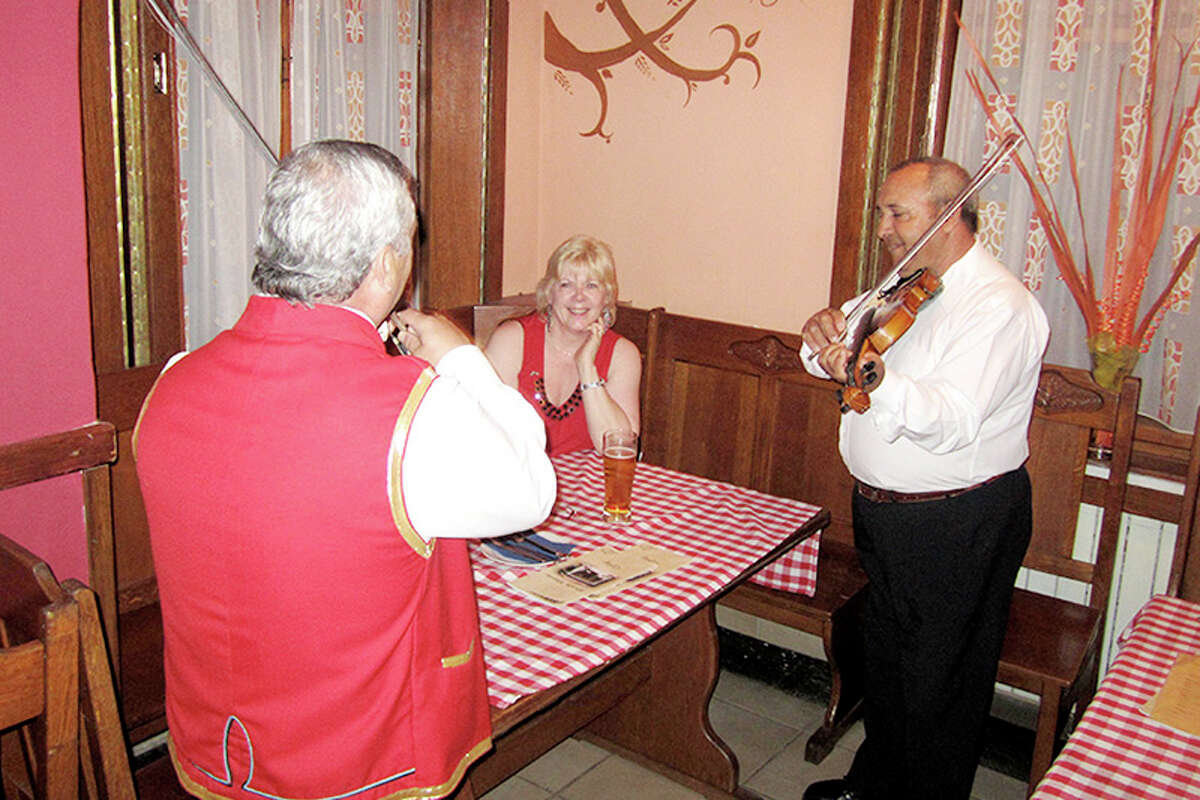 TRAVEL BEYOND: Diane Griffin is serenaded during a 2011 trip to Hungary she took with her husband, Rick, so he could teach at a university there. (Courtesy photo)
