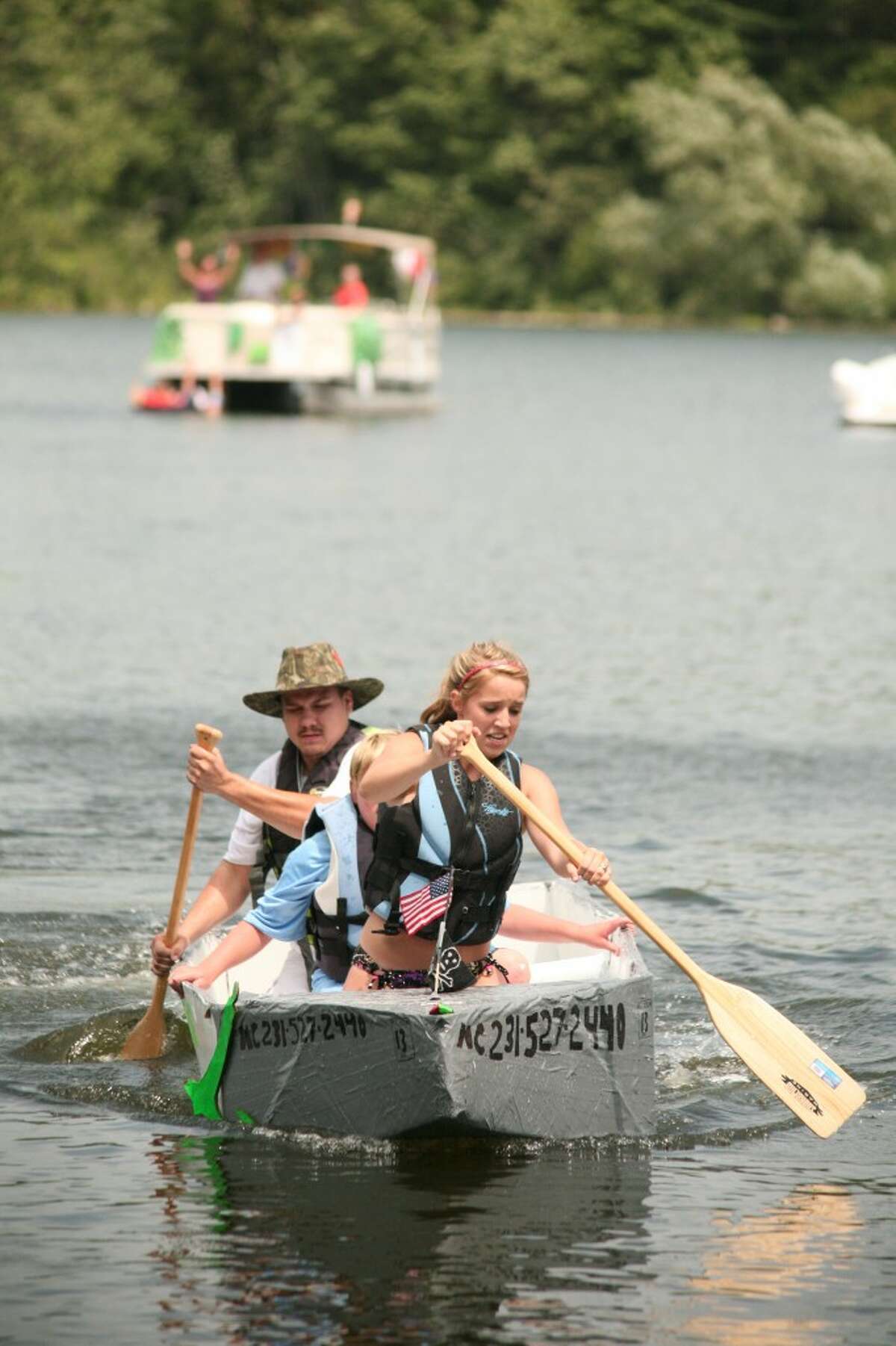 CARDBOARD BOAT: Joel Nichols (at stern) captains the "S.S. Let it Float" cardboard boat during Saturday's Damsel in Distress Rescue competition. The event was part of the inaugural Dam Festival in Rogers Heights.
