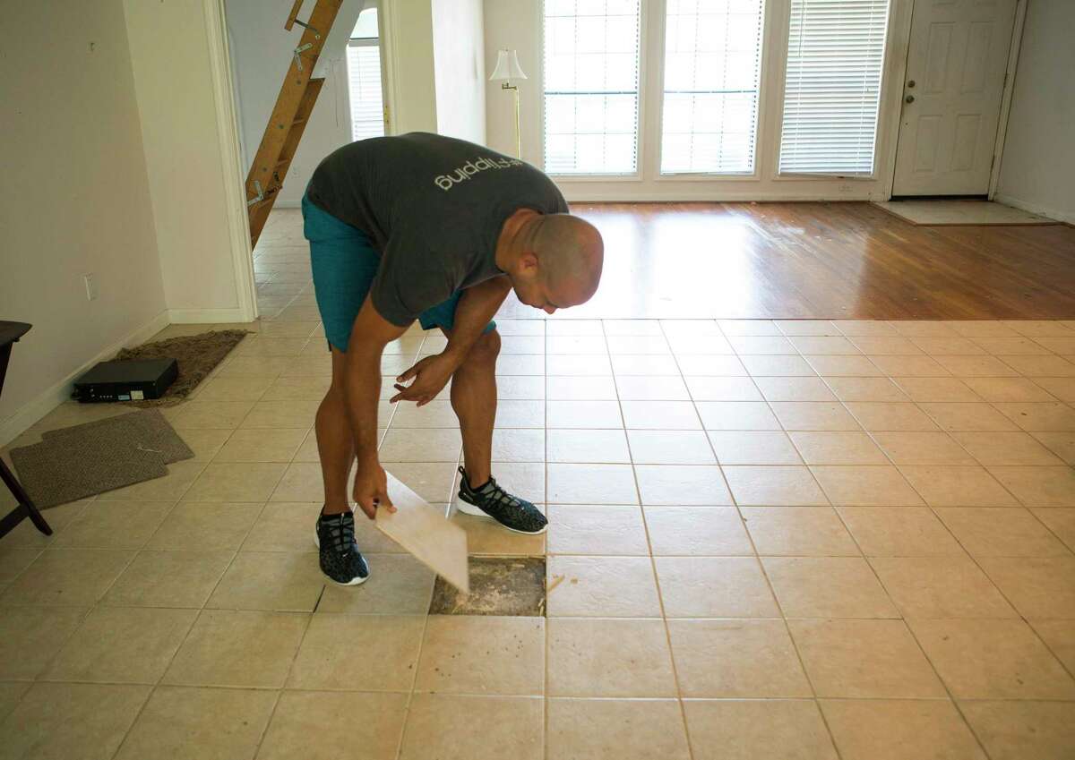 Jon Tjon-Joe-Pin looks under the existing tile in a home he is flipping with his wife, Mary, in the Oak Forest neighborhood, Tuesday, July 9, 2019. The couple have a new show called "Going for Sold" debuting in August on HGTV about flipping Houston real estate. But even as flipping grows in popularity, returns have shrunk.