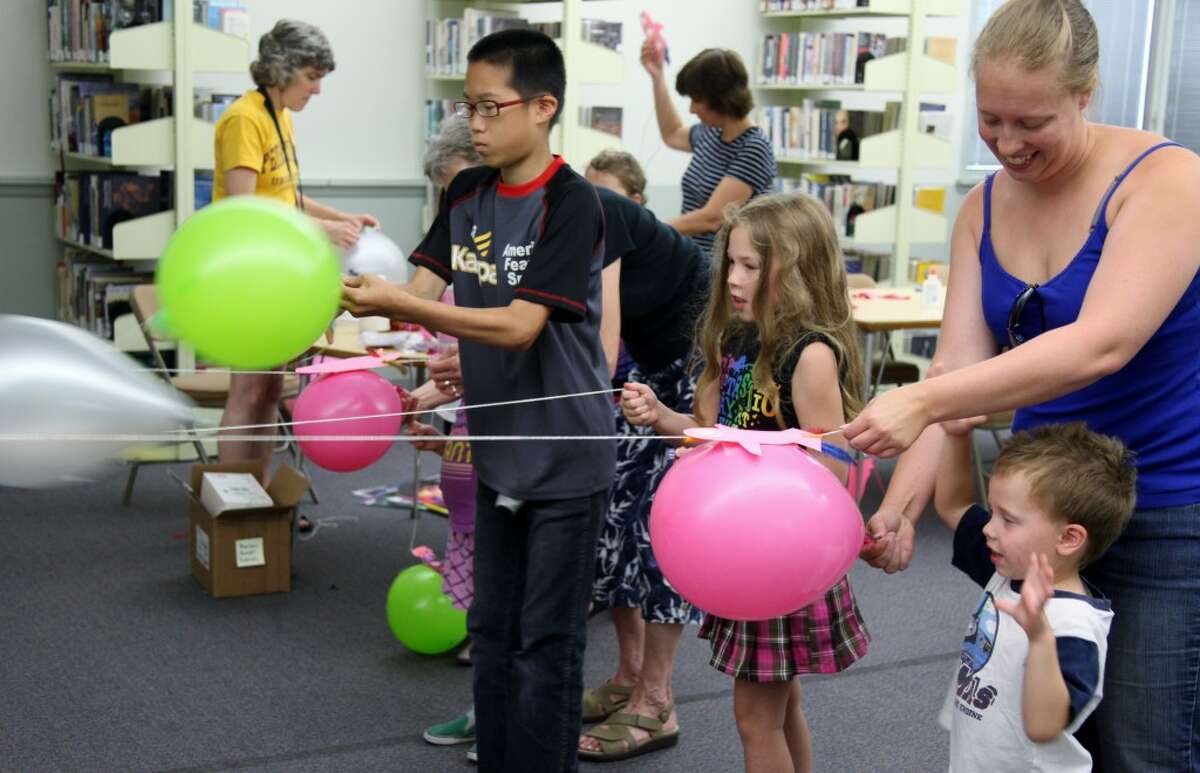 OFF TO THE RACES: A group of children lines up to race the rockets they made at a summer reading program event on Tuesday at the Big Rapids Community Library. Rockets complement the program’s focus on the night sky and space, which goes along with the theme “dream big.” (Pioneer photos/Lauren Fitch)