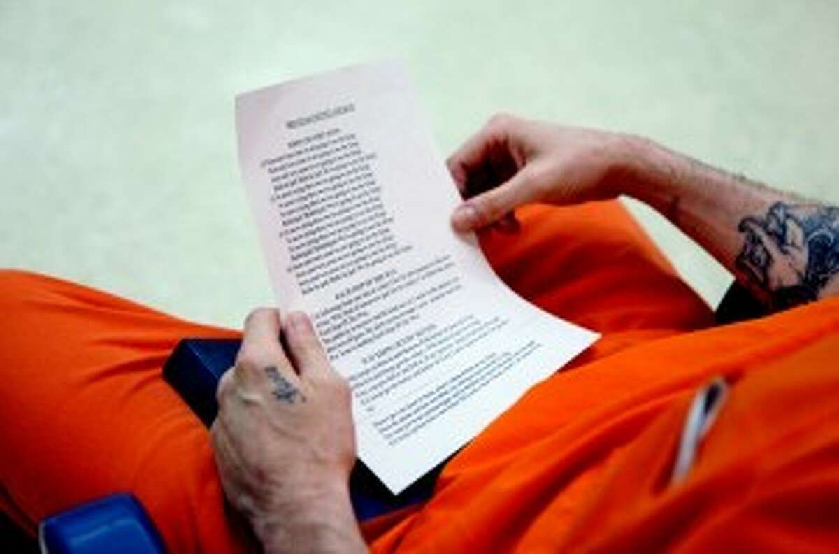 MECOSTA COUNTY CHURCH: A jail inmate holds a song sheet from "Mecosta County Church," an affectionate name for the church service provided for inmates by Forgotten Man Ministries. (Pioneer photos/Whitney Gronski-Buffa)