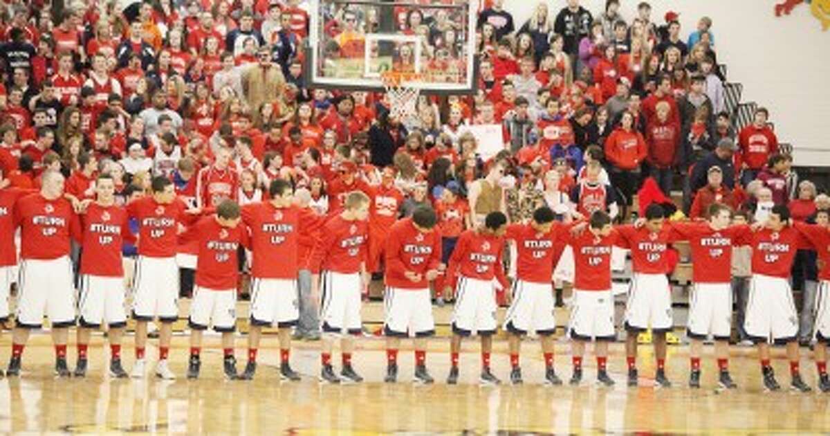 ALL TOGETHER: The Big Rapids boys basketball team lock arms before the National Anthem on Tuesday before the Class B quarterfinal contest at Jim Wink Arena. (Pioneer photo/Bob Allan)