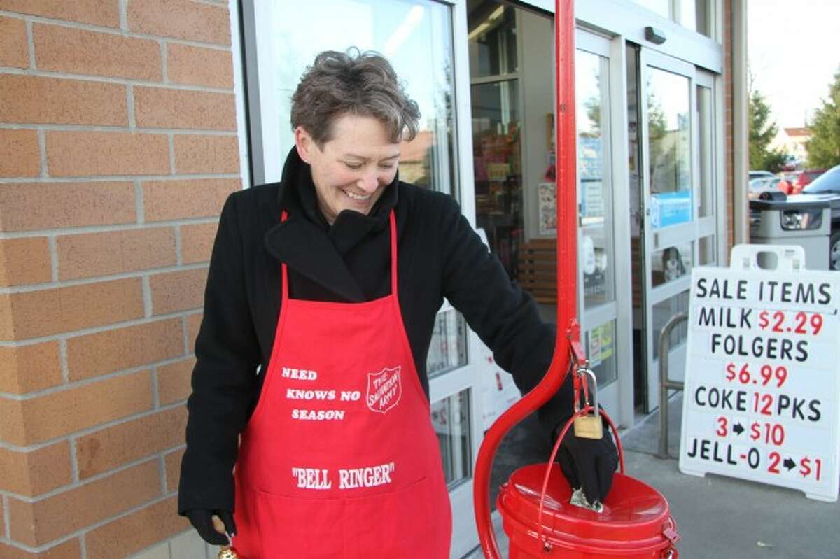 RINGING THE BELL: Andrea Nerbonne, director of public safety in Big Rapids, puts a dollar in the red kettle at Walgreens on Thursday. (Pioneer photo/Miranda Roberts)