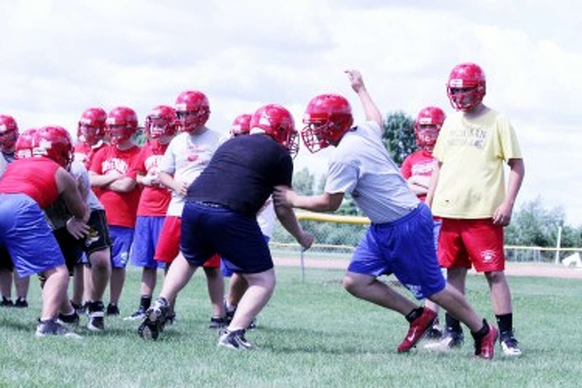 READY: Chippewa Hills senior Hayden Denslow (right) goes through a defensive drill during the first day of football practice. (Pioneer photo/Bob Allan)