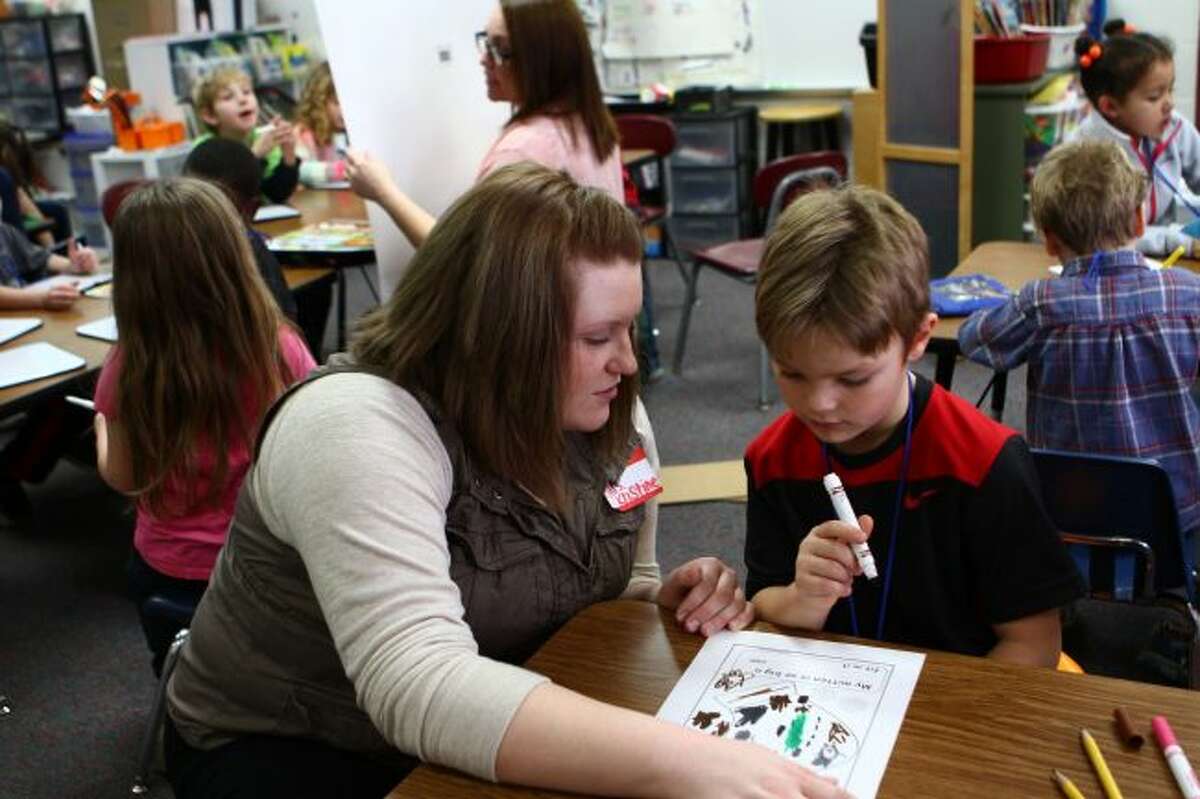 Ferris State University student Kristine Moulter (left) works with Riverview kindergartner Ethan Amyx on a worksheet as a portion of her final exam. (Pioneer photo/Meghan Gunther-Haas)