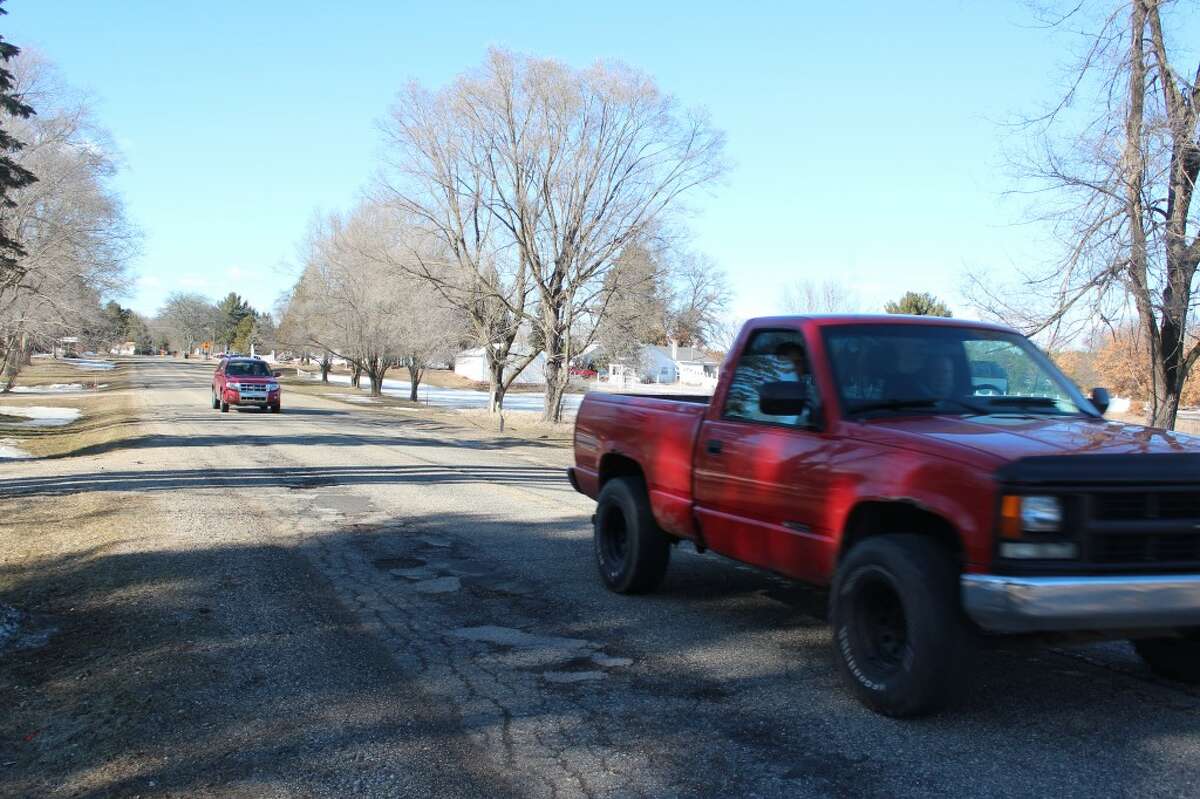 STEERING CLEAR: Drivers on New Millpond Road drive around the large patch of potholes. Potholes are created from moisture seeping into concrete or asphalt cracks and expanding when the pavement re-freezes. (Pioneer photos/ Lauren Gentile)