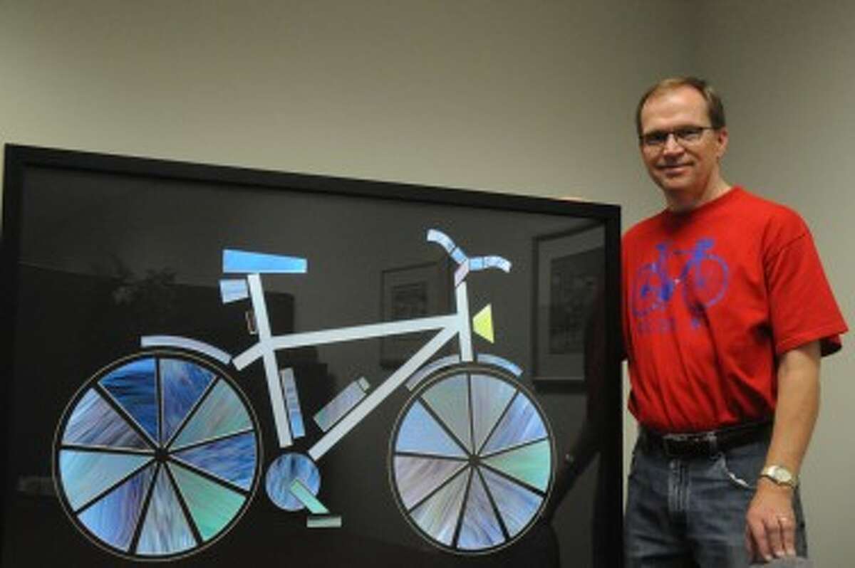 ACCIDENTAL ART: Dr. Ralph Crew stands with his ArtPrize submission. After accidentally taking a photo with his cell phone while riding his bicycle, Crew recreated the mistake to produce the artwork. (Pioneer photo/Kyle Leppek)