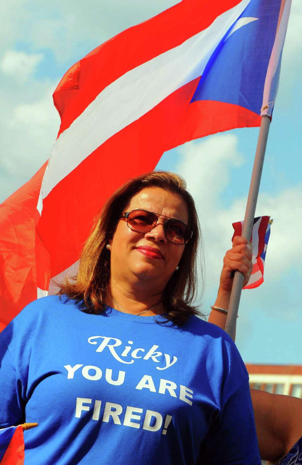 Lissette Colon, who works for the city of Bridgeport, wears a t-shirt celebrating the resignation of the Puerto Rican Governor Ricardo Rosselló during a rally at Baldwin Plaza in downtown Bridgeport, Conn., on Thursday July 25, 2019. The rally was held in solidarity with the people in San Juan, Puerto Rico who protested, leading to the resignation of Rosselló last night.