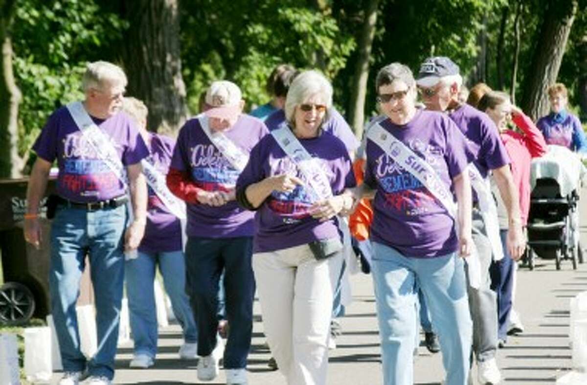 SURVIVORS’ LAP: A group of cancer survivors walk together during the Survivors’ Lap at the 2011 Relay for Life. Seventy-five local survivors were honored at the event. (Pioneer file photos)
