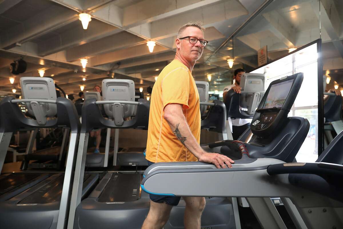 Kindergarten teacher Tim Simpson starts on the tread mill in the gym before his weight workout at Fitness SF Castro on Thursday, July 25, 2019 in San Francisco, Calif. The teacher had to pay for his own sub when he needed open heart surgery to fix a valve defect.
