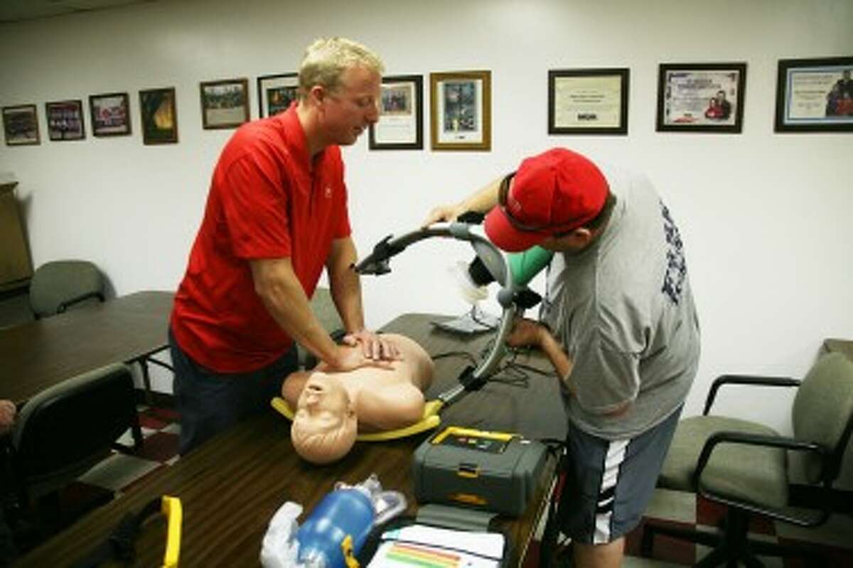 Curt Zondervan (in red) instructs Billy Johnson on how to use the Lucas 2 Chest Compression System.
