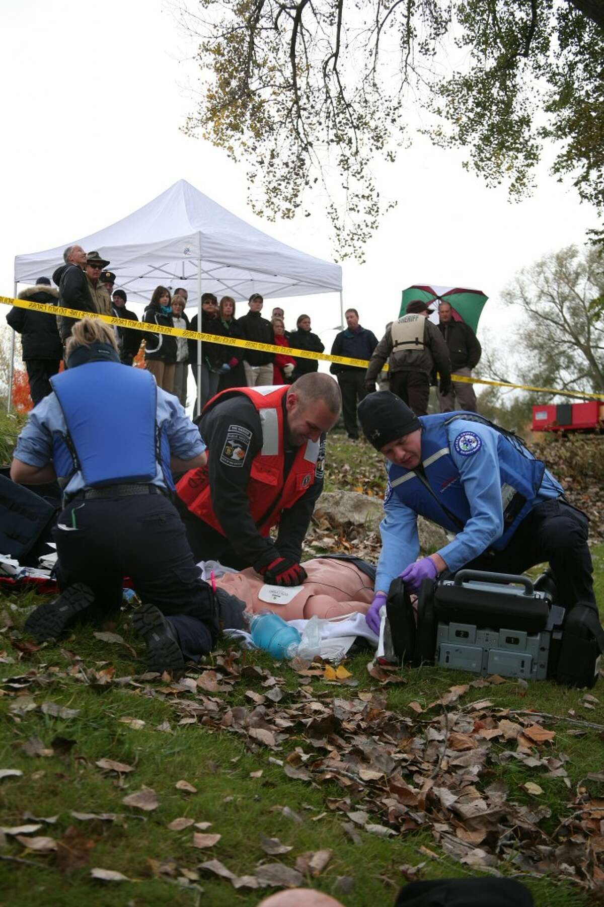 RESCUE DEMONSTRATION: First responders perform CPR on a “dummy” during a simulated Muskegon River rescue demonstration on Thursday at Hemlock Park. Students from the 2012-13 Leadership Mecosta class watch from the shore during its public safety day. (Pioneer photos/Jonathan Eppley)
