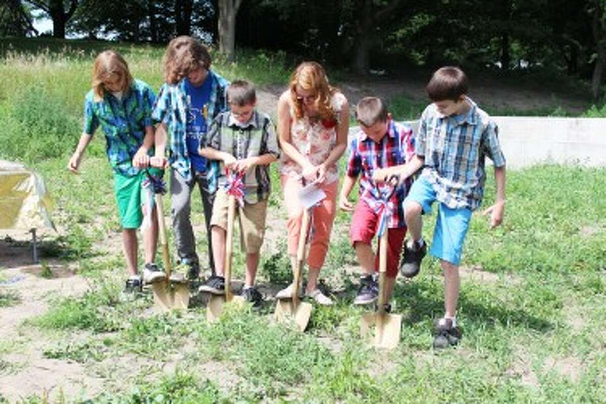 BREAKING GROUND: Marcy Jo Scott and her five sons break ground on Thursday at the site of their Habitat for Humanity home, which will be built in Reed City.