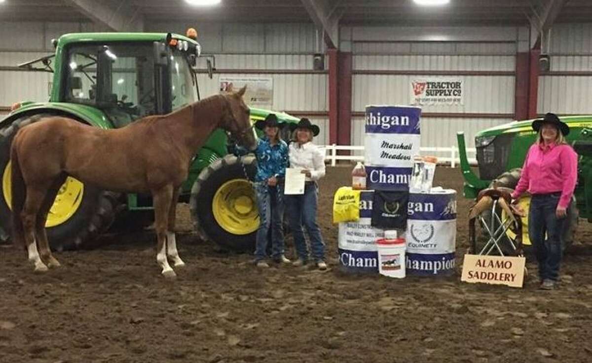 CHAMPION: Bobbi Hinkley stands with her horse and poses for a photo with National Barrel Horse Association Michigan State Director Diane Loosenort after Hinkley won the state championship. Jenny Hough, a representative for Sobie Company, a first-year saddle sponsor, also is pictured.