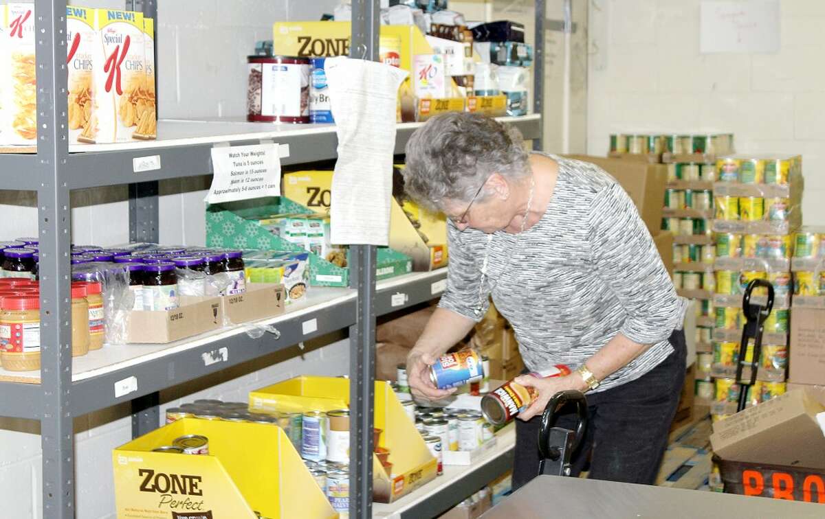 RECORD DEMAND: A volunteer at Project Starburst stocks shelves. The Big Rapids food pantry has seen its highest demand ever in recent months, with greater need expected in June and July. (Pioneer file photo)