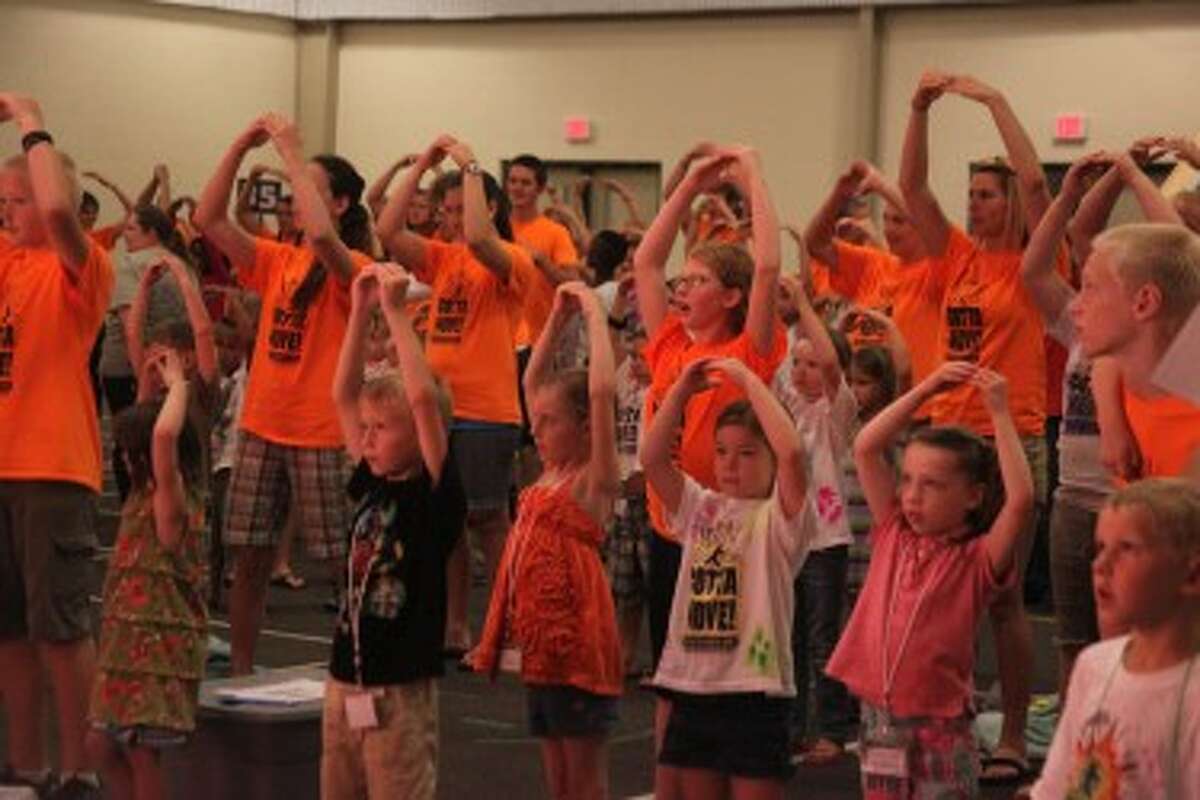 GOTTA MOVE: Vacation Bible schoolers raise their arms like the sun in the multipurpose room at Trinity Fellowship on Wednesday. (Pioneer photo/Miranda Roberts)