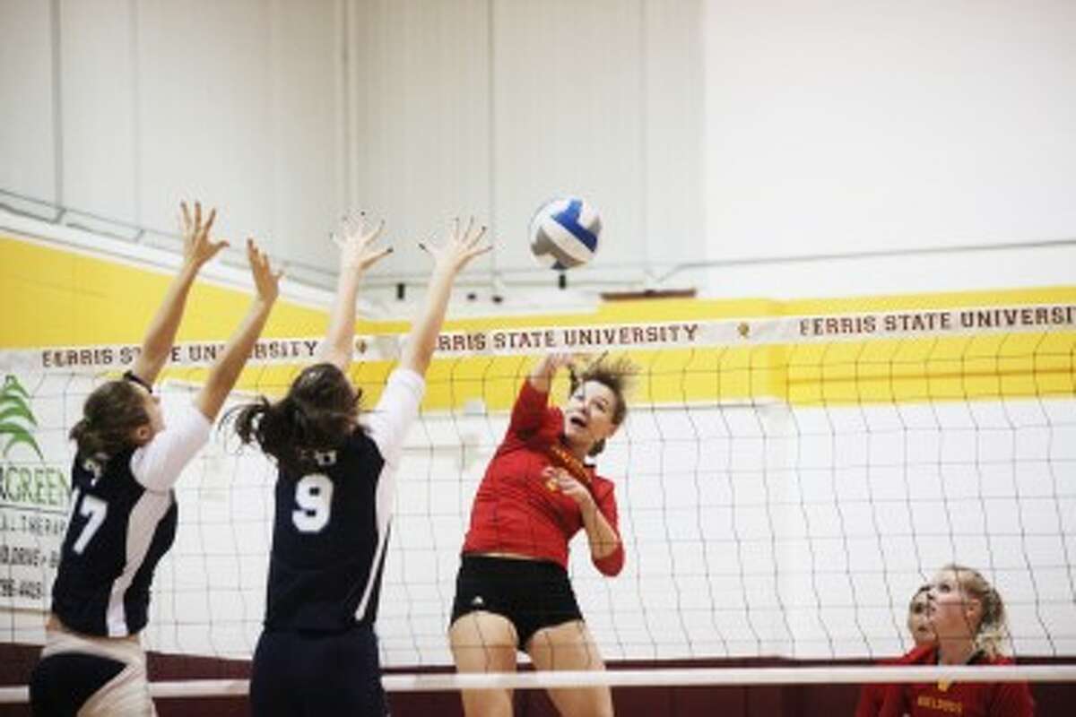 OUT OF REACH: Ferris State’s Megan Vander Meer hits the ball past a pair of Northwood defenders during Saturday’s 3-0 victory over the Timberwolves. (Pioneer photo/Bob Allan)