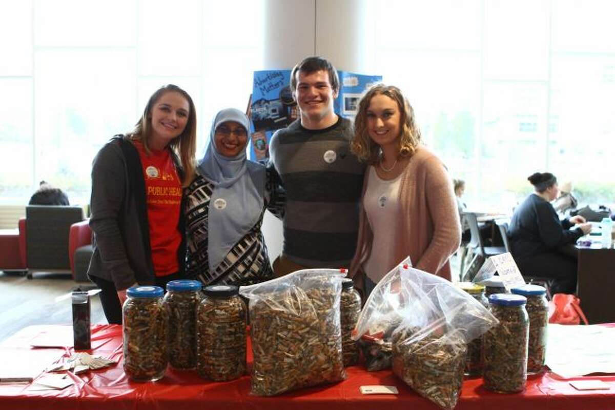 Ferris State University research students (from left) Ali Quilitzsch, Anthony Picard and Alyson Hill, and their adviser (second from left) Fathima Wakeel, are working together to make the college a tobacco-free campus. The group set up tables at the University Center on campus to speak with students, staff and faculty about tobacco use. (Pioneer photos/Meghan Gunther-Haas)