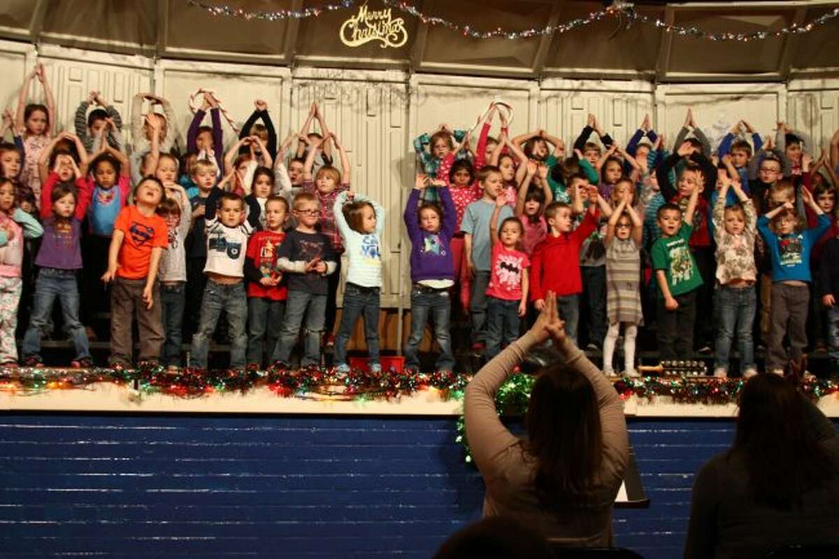 IN MOTION: Students follow their teachers hand motions while performing a song during rehearsal for the kindergarten and first grade Barryton Elementary School Holiday Program.