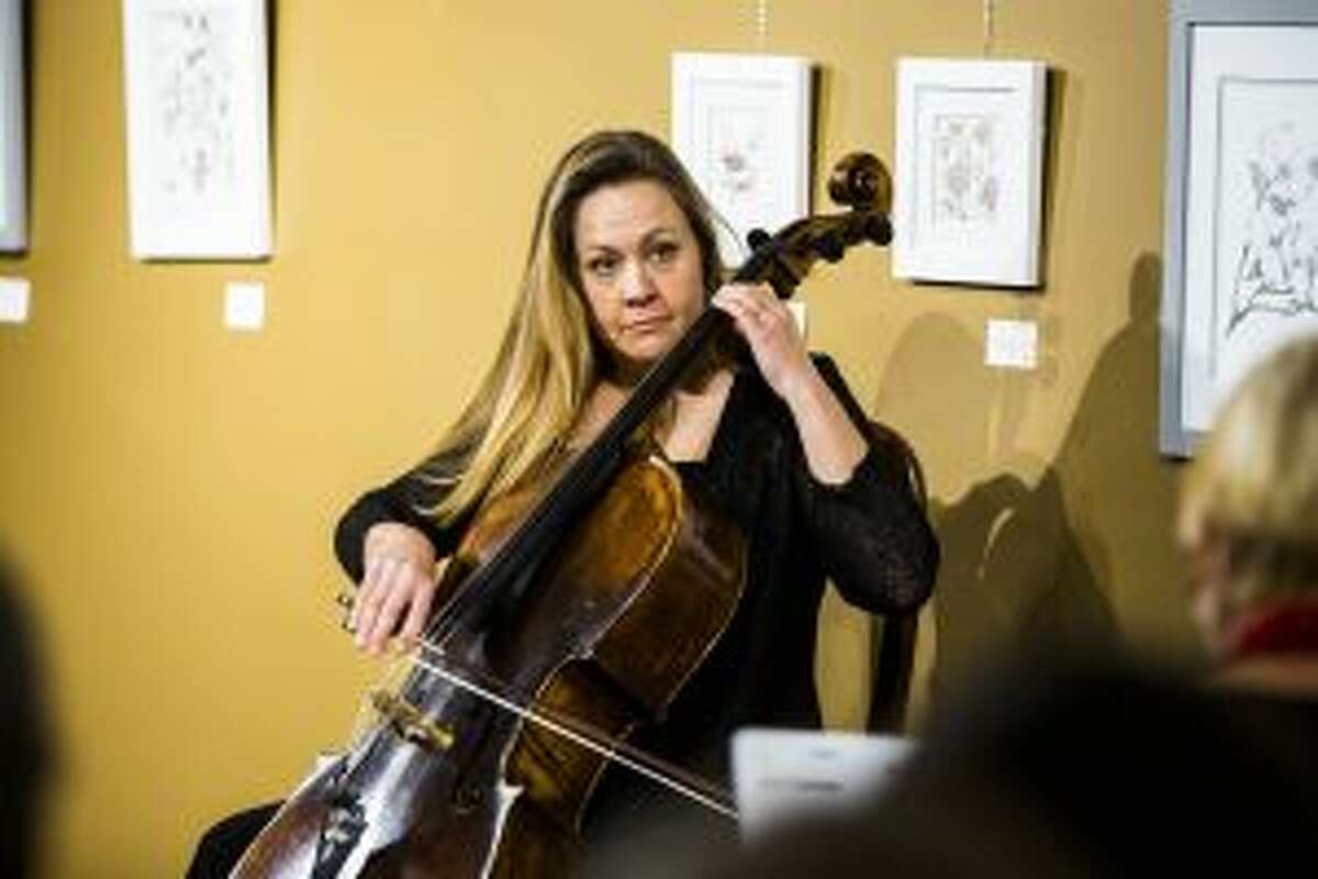 HOLIDAY HARMONY: Laura Taylor gives the cue for accompaniment while she plays "O Come O Come Emmanuel" on cello.