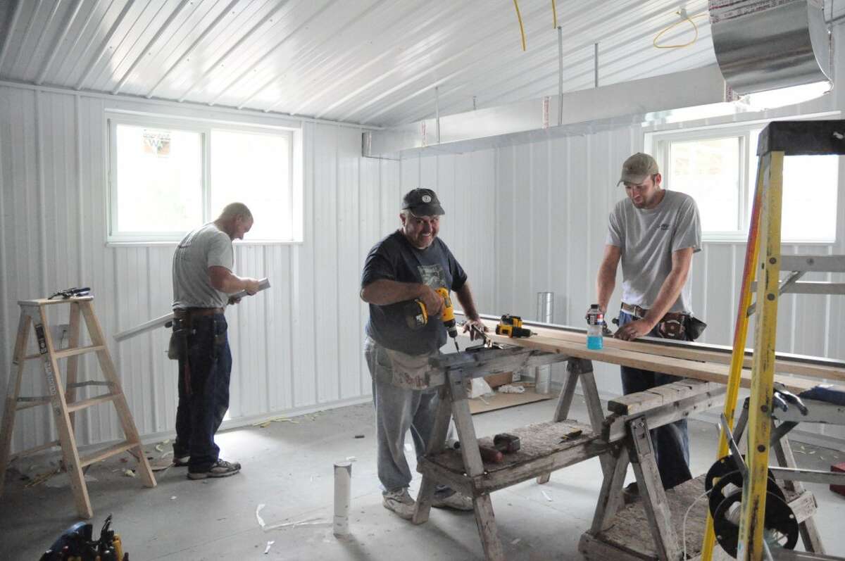 FINISHING UP: A construction crew works on the new Mecosta County animal shelter on Thursday. The 3,300-square-foot shelter will house 25 dogs and 35 cats at one time. The facility is expected to be complete by Aug. 20. (Pioneer photo/Kyle Leppek)