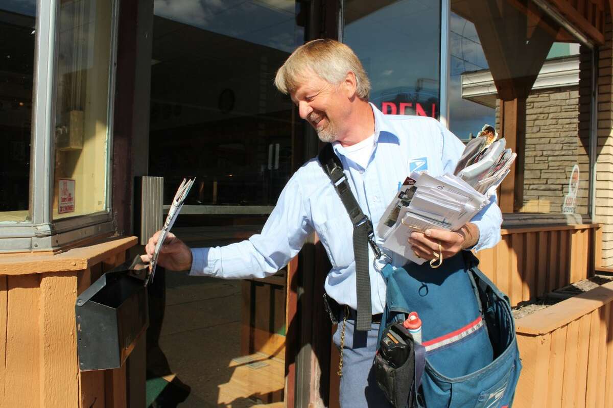 MAIL TIME: Long-time mail carrier Bill Rogers makes a delivery to Pompeiis Pizza in downtown Reed City. Rogers said if he wasn’t he the mail business, he would like to be a farmer. (Pioneer photos/Sarah Neubecker)