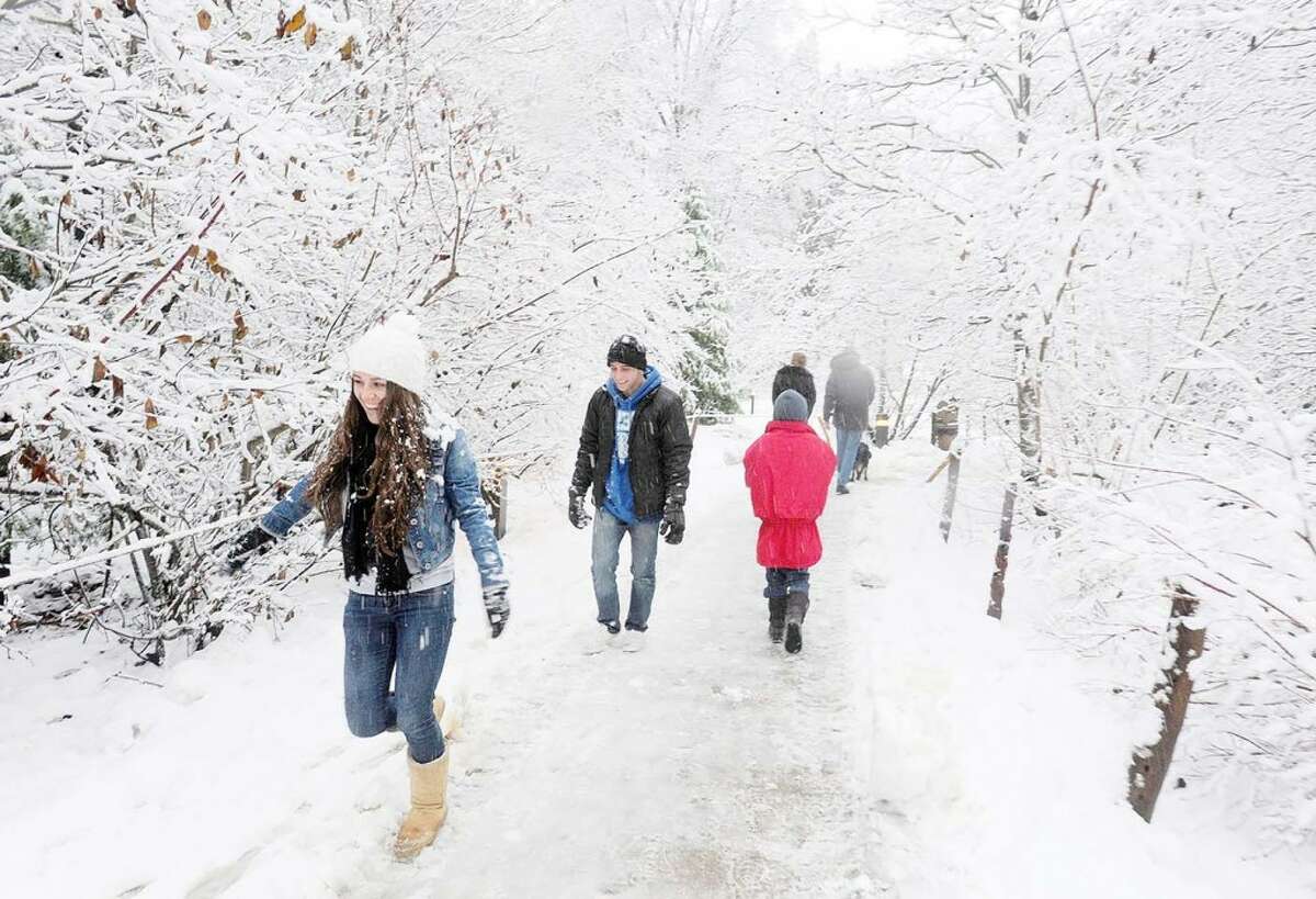 SNOW FALL: Yosemite Valley, Calif., visitors walk through the snow covered walkways of Curry Village on Sunday. (MCT News Service)
