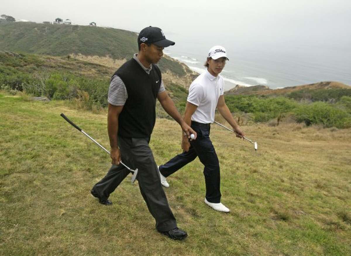 In this June 9, 2008, file photo, Tiger Woods, left, walks with amateur Jordan Cox along the cliff between the third and fourth holes at Torrey Pines during a practice round for the U.S. Open golf tournament in San Diego. Woods’ win 10 years ago is his most recent victory in a major. (AP Photo/Chris Carlson, File)