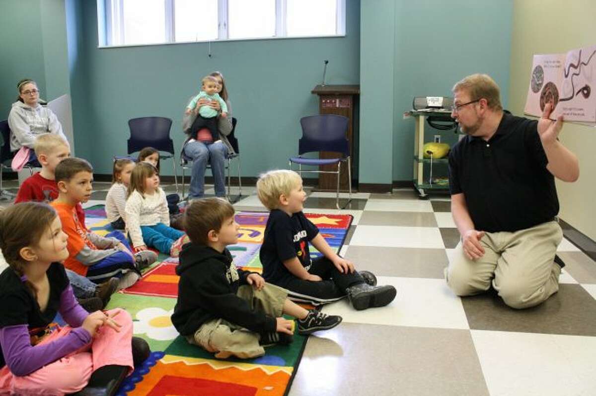 Howard Botma, story time programmer at the Big Rapids Community Library, reads to children during story time at the library. In honor of March as National Reading Month, a variety of guest readers will stop by the library throughout the month to read to kids. (Pioneer file photo)