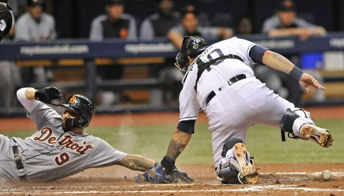 Tampa Bay Rays catcher Wilson Ramos, right, drops the ball as Detroit Tigers’ Nicholas Castellanos scores on a two-run double by Detroit’s Jose Iglesias during the seventh inning of a baseball game Monday, July 9, 2018, in St. Petersburg, Fla. (AP Photo/Steve Nesius)