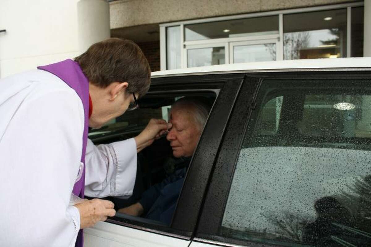 The Rev. Rebecca Morrison places ashes on a man's forehead during Drive Thru Ashes in 2017. Big Rapids First United Methodist Church will again offer the service from 7 a.m. to 6 p.m. on Wednesday, Feb. 14, at the covered entryway on the Warren Avenue side of the church. (Pioneer file photo)