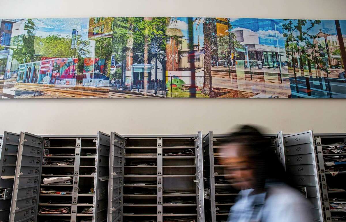 A photo-based conceptual art piece by David A. Brown hangs above the mailboxes inside the Mid Main Lofts in Houston, Thursday, July 25, 2019. Lane and Bob Schultz have worked to fill much of the common areas along Main Street in that section of midtown with public art form murals to window displays in currently vacant buildings.
