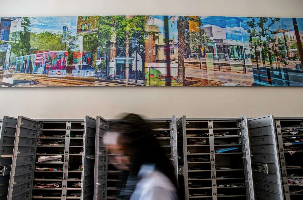 A photo-based conceptual art piece by David A. Brown hangs above the mailboxes inside the Mid Main Lofts in Houston, Thursday, July 25, 2019. Lane and Bob Schultz have worked to fill much of the common areas along Main Street in that section of midtown with public art form murals to window displays in currently vacant buildings.