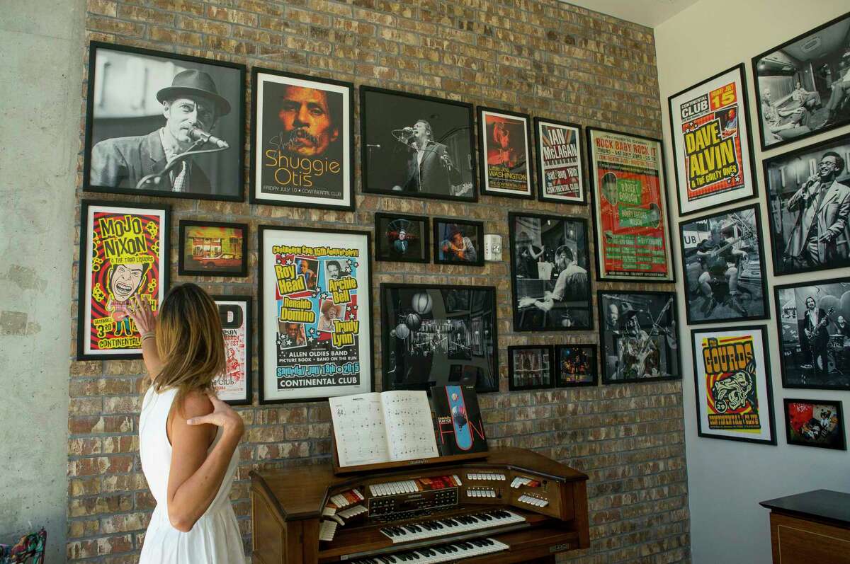 Lane Schultz points out the concert posters and photographs from photographer Jay Lee filling the walls on a common area that serves as a gallery inside the Mid Main Lofts in Houston, Thursday, July 25, 2019. Schultz and her husband, Bob, have worked to fill much of the common areas along Main Street in that section of midtown with public art form murals to window displays in currently vacant buildings.