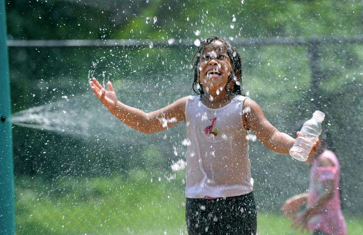 In this photo taken Aug. 7, 2018, Elia Backus, 5, cools off at the Highland Avenue Spray Park in Danbury.