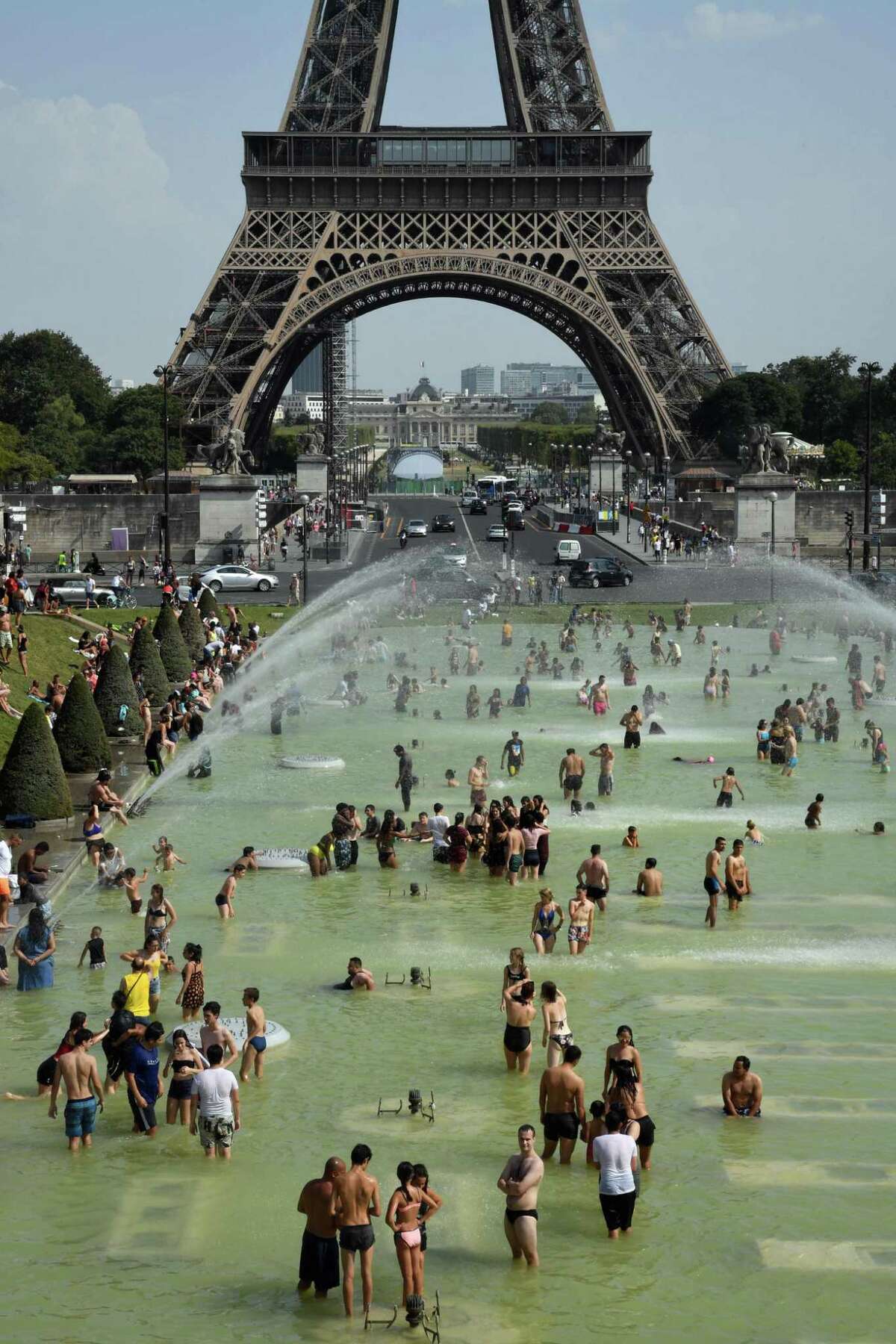 People cool off at the Trocadero Fountains next to the Eiffel Tower in Paris, on July 25, 2019 as a new heatwave hits the French capital. All-time temperature records were smashed in Belgium, Germany and the Netherlands on July 24.