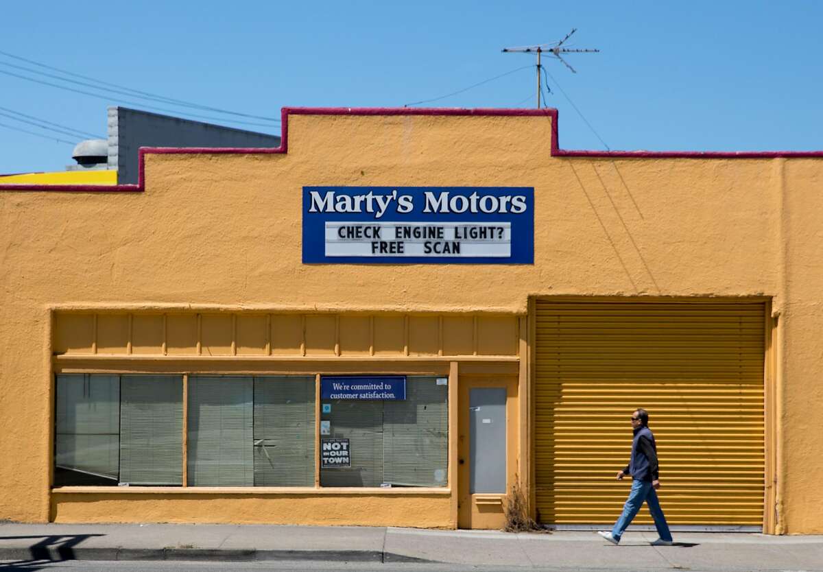 A man walks past Marty's Motors along San Pablo Avenue in El Cerrito, Calif. Tuesday, July 16, 2019.